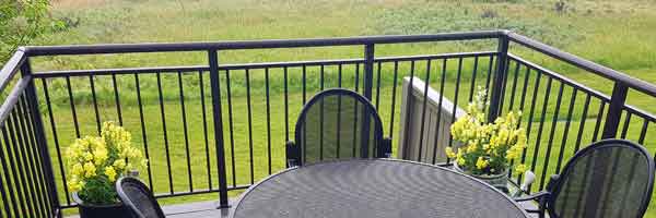 A man and a woman are enjoying a breakfast on their patio with the sun rising over them.